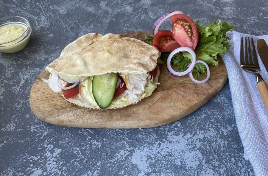 Шаурма в пите с курицей и овощами на деревянной доске