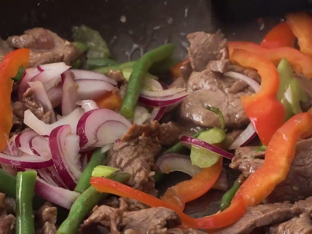 Говядина с болгарским перцем, стручковой фасолью и красным луком на сковороде для лагмана