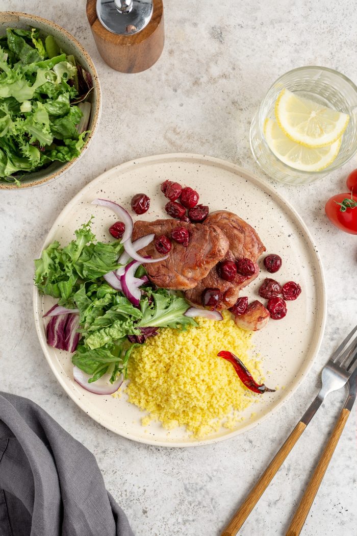 Медальоны из свинины с вишнёвым соусом, кус-кусом и зелёным салатом
