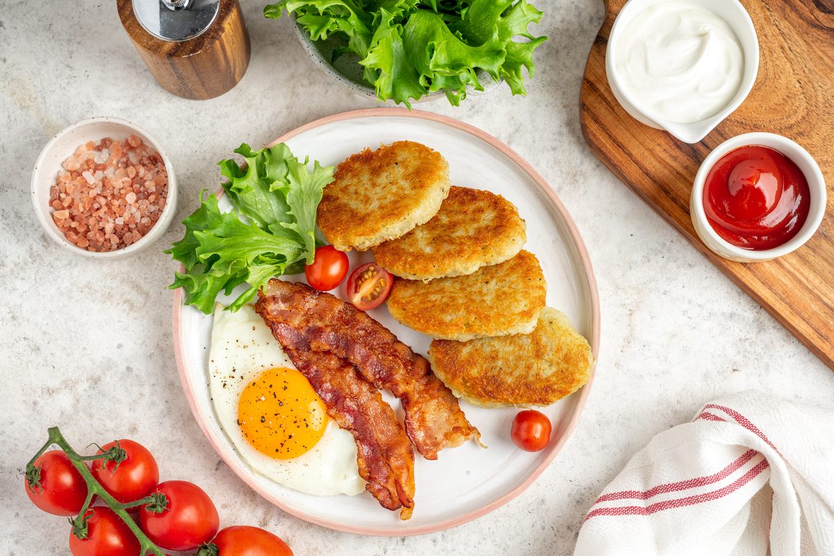 Хашбрауны с беконом и глазуньей на тарелке